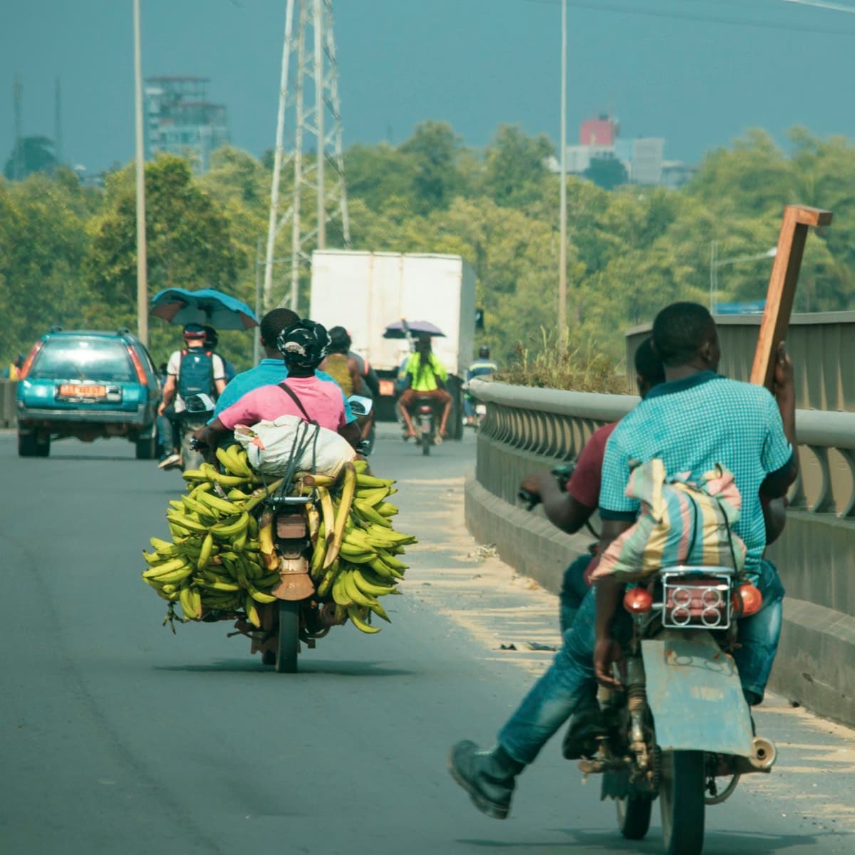Une moto chargée de régimes de plantains sur une route animée de Douala, au Cameroun
